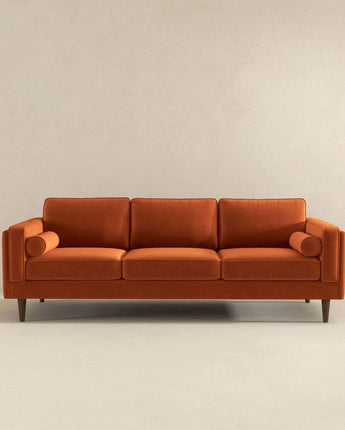 Luxurious Amber Burnt Orange Velvet Sofa in a modern living room.